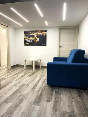 a living room with a blue couch and a table at Life Rooms in Misilmeri