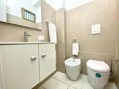 a bathroom with a white toilet and a sink at Casa Perla Marina sul mare in Castellammare del Golfo
