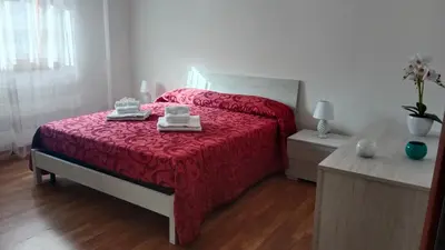 a bedroom with a red bed with two towels on it at Kalisa Home, B&B e Casa Vacanza Palermo in Capaci