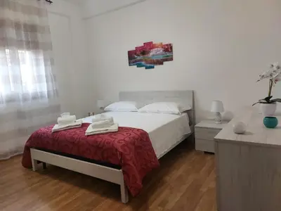 a bedroom with a bed with a red blanket at Kalisa Home, B&B e Casa Vacanza Palermo in Capaci