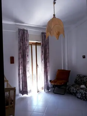 a living room with a large window and a couch at Casa vacanze zina in Altavilla Milicia