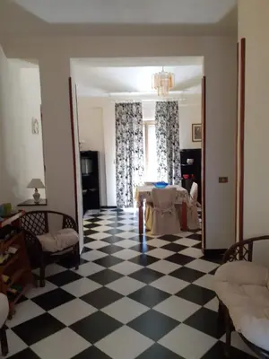 a living room with a table and a checkered floor at Casa vacanze zina in Altavilla Milicia