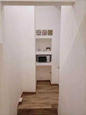 a stairway with a microwave in a white room at Thalia in Palermo