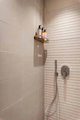 a bathroom with a shower with a hose on the wall at LE PORTE DEL KASSARO in Palermo