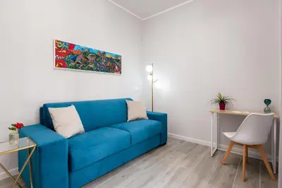 a blue couch in a living room with a table at LE PORTE DEL KASSARO in Palermo