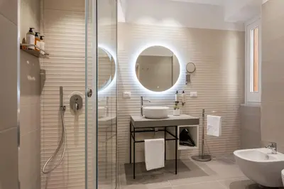 a bathroom with a sink and a shower and a mirror at LE PORTE DEL KASSARO in Palermo