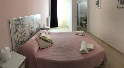 a bedroom with a pink bed with towels on it at Villa MiraScopello in Castellammare del Golfo