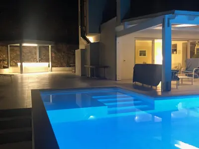 a large swimming pool in a house at night at Villa MiraScopello in Castellammare del Golfo