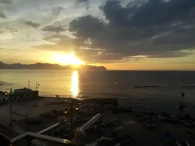 a sunset over a body of water with the sun setting at La casa di Jack in Bagheria