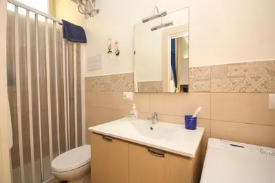 a bathroom with a sink and a toilet and a mirror at La casa di Jack in Bagheria