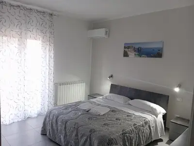 a white bedroom with a bed and a window at Golden House con jacuzzi in Castellammare del Golfo