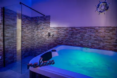 a bathroom with a tub with a glass shower at Golden House con jacuzzi in Castellammare del Golfo
