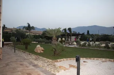 a garden with palm trees and plants in a building at Villa Albamonte in Carini
