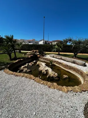 a pond with rocks in the middle of a park at Villa Albamonte in Carini