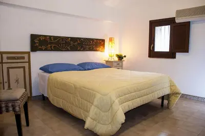 a bedroom with a large bed with blue pillows at Bed And Breakfast Maria in Scopello