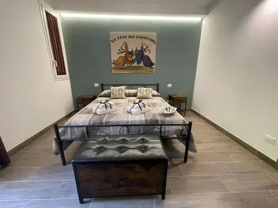 a bed in a room with a table and a bench at La Casa Dei Cavalieri in Caccamo