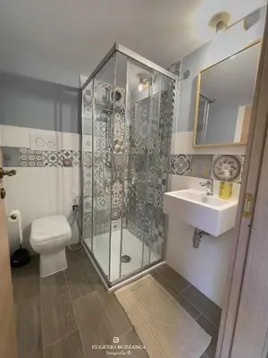 a bathroom with a shower and a toilet and a sink at La Casa Dei Cavalieri in Caccamo