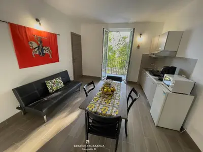 a small living room with a table and a kitchen at La Casa Dei Cavalieri in Caccamo