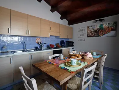 a kitchen with a wooden table with chairs and a sink at La Casa di Filippo in Palermo