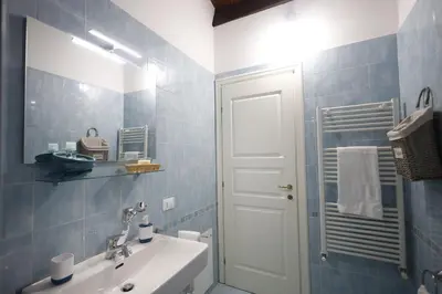 a blue tiled bathroom with a sink and a mirror at La Casa di Filippo in Palermo