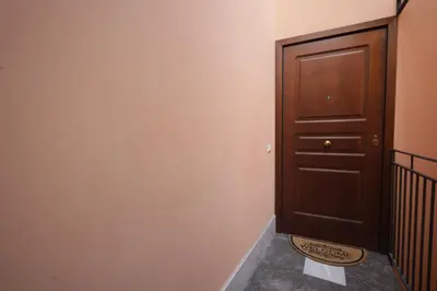 a hallway with a wooden door and a staircase at La Casa di Filippo in Palermo