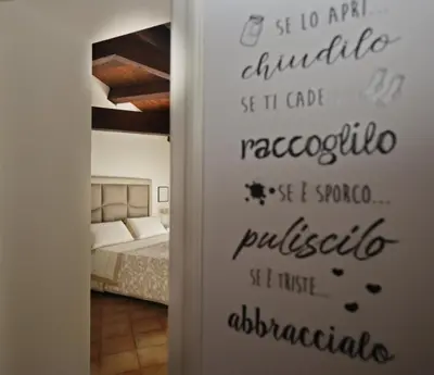 a bedroom with a door with words on the wall at La Casa di Filippo in Palermo