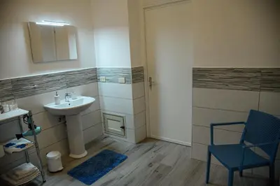 a bathroom with a sink and a blue chair at Kalsa Casa dei Mori in Palermo