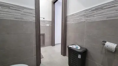 a bathroom with a toilet and a trash can at Holiday House Lady in Terrasini