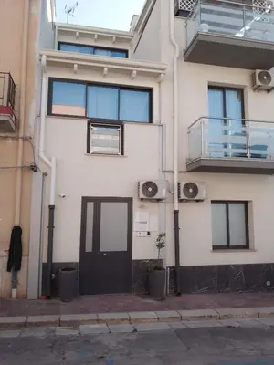 a white building with a door and a balcony at Holiday House Lady in Terrasini