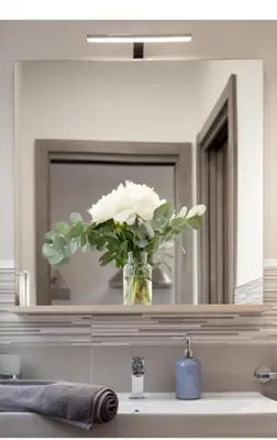 a vase of white flowers sitting on top of a bathroom sink at Holiday House Lady in Terrasini