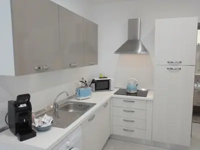 a white kitchen with a sink and a microwave at Holiday House Lady in Terrasini