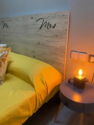 a bedroom with a yellow bed and a table with a candle at La Terrazza del Capo in San Vito lo Capo