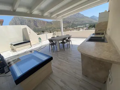 a kitchen with a view of a table and chairs at La Terrazza del Capo in San Vito lo Capo