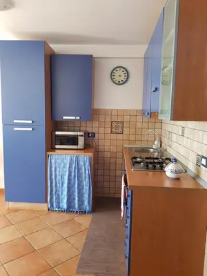 a kitchen with blue cabinets and a stove top oven at Calipso in Bagheria