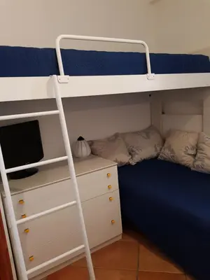 a bunk bed with a ladder next to a desk at Calipso in Bagheria