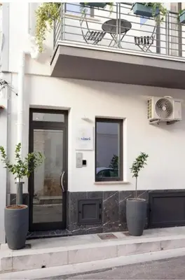 a building with two potted plants in front of a door at Holiday House Monalisa in Terrasini