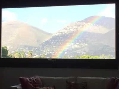 a large screen with a rainbow behind a couch at Mondello Luxury Apartment on the Beach in Mondello