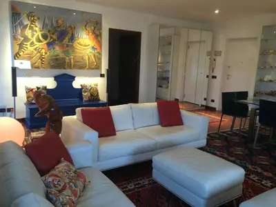 a living room with a white couch and red pillows at Mondello Luxury Apartment on the Beach in Mondello
