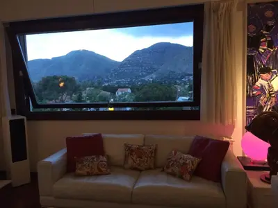a couch in a living room with a large window at Mondello Luxury Apartment on the Beach in Mondello