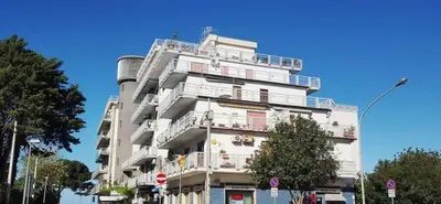 a white building with balconies on the side of it at Mondello Luxury Apartment on the Beach in Mondello