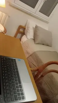 a laptop computer sitting on a table next to a couch at Nido del falco in Mondello