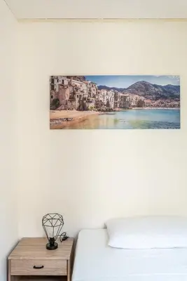 a bedroom with a bed and a table with a picture on the wall at I Mori-holiday apartment in Palermo