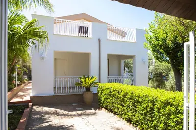 a white house with a hedge in front of it at La Murgiulina in Carini