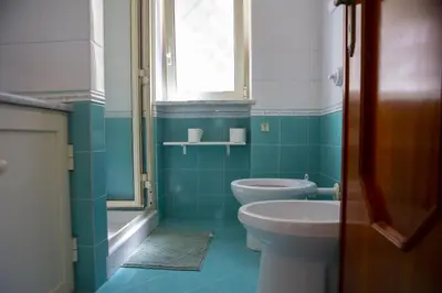 a bathroom with a toilet and a sink and a window at La Murgiulina in Carini
