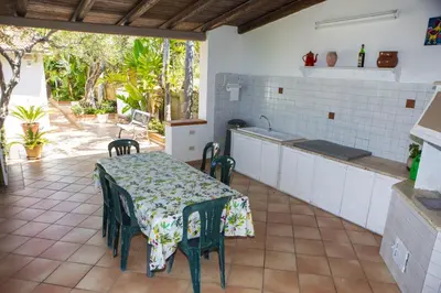 a kitchen with a table and chairs in a room at La Murgiulina in Carini