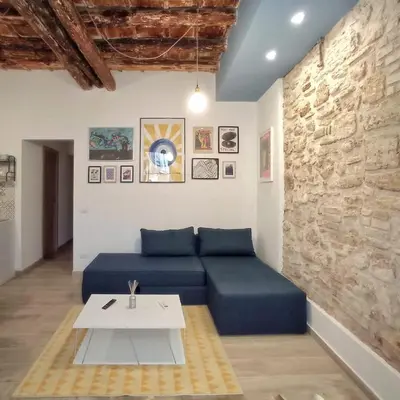 a living room with a blue couch and a table at PalermHost in Palermo
