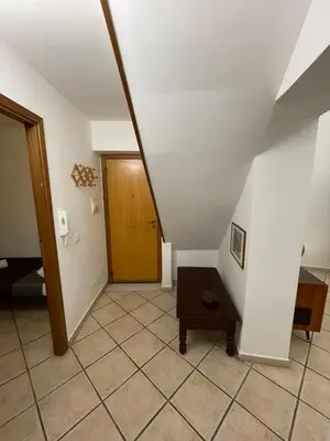 a hallway with a staircase with a wooden door at Sicooli apartments via Materassai 46 in Palermo