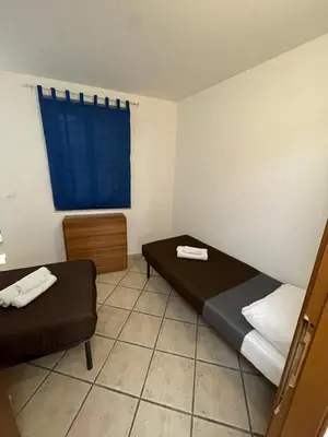 a small room with two beds and a window at Sicooli apartments via Materassai 46 in Palermo