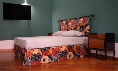 a bedroom with a bed with a floral head board at Le Radici casa vacanze in Palermo