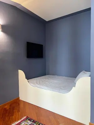 a bedroom with a white bed and a tv on a wall at Le Radici casa vacanze in Palermo